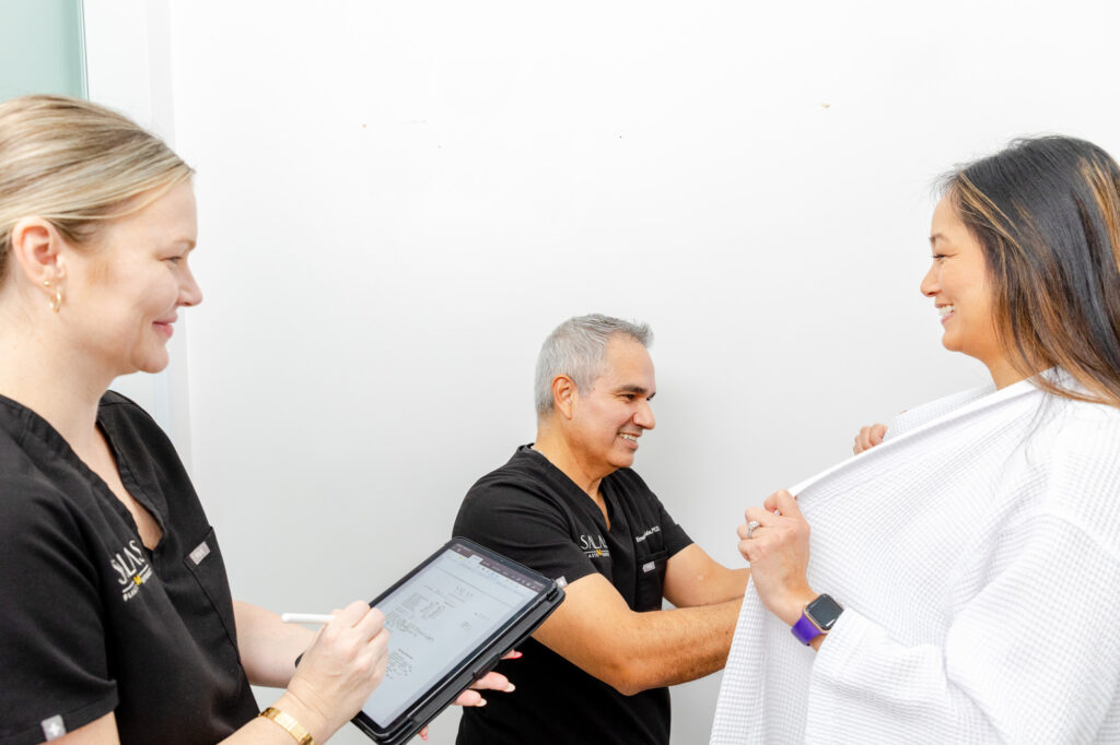 Dr. Salas examines a patient's breasts in preparation for a breast aug in Pembroke Pines.