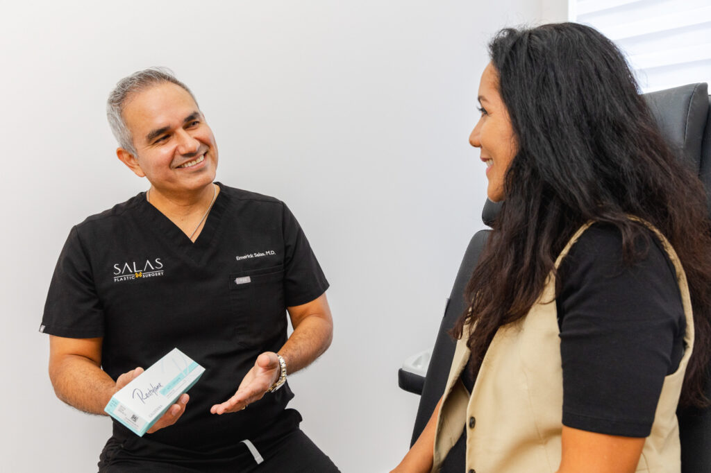 Dr. Salas explaining dermal fillers to a patient who's at our clinic to treat her Sun Damage in Pembroke Pines.