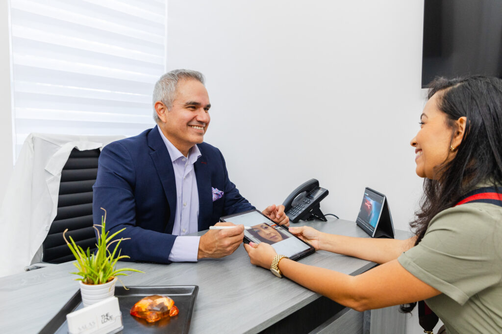 Dr. Salas meets with a patient about an eyelid lift. She tells him her desires, and he maps out her plastic surgery near Pembroke Pines.