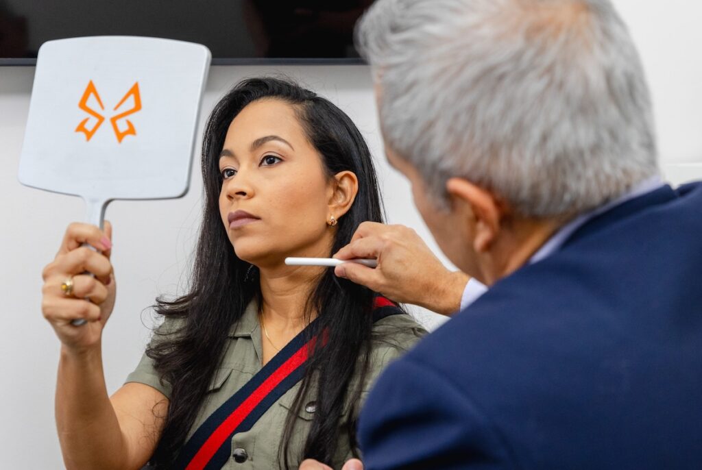 Dr. Salas examines a patient's jawline and neck area to help her find the best neck firming treatment in Pembroke Pines.